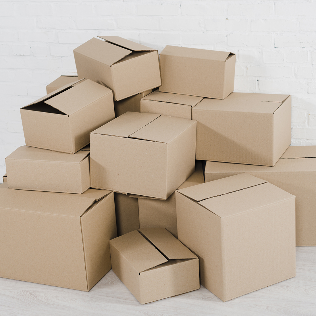 Pudła klapowe z tektury ułożone w stosie
